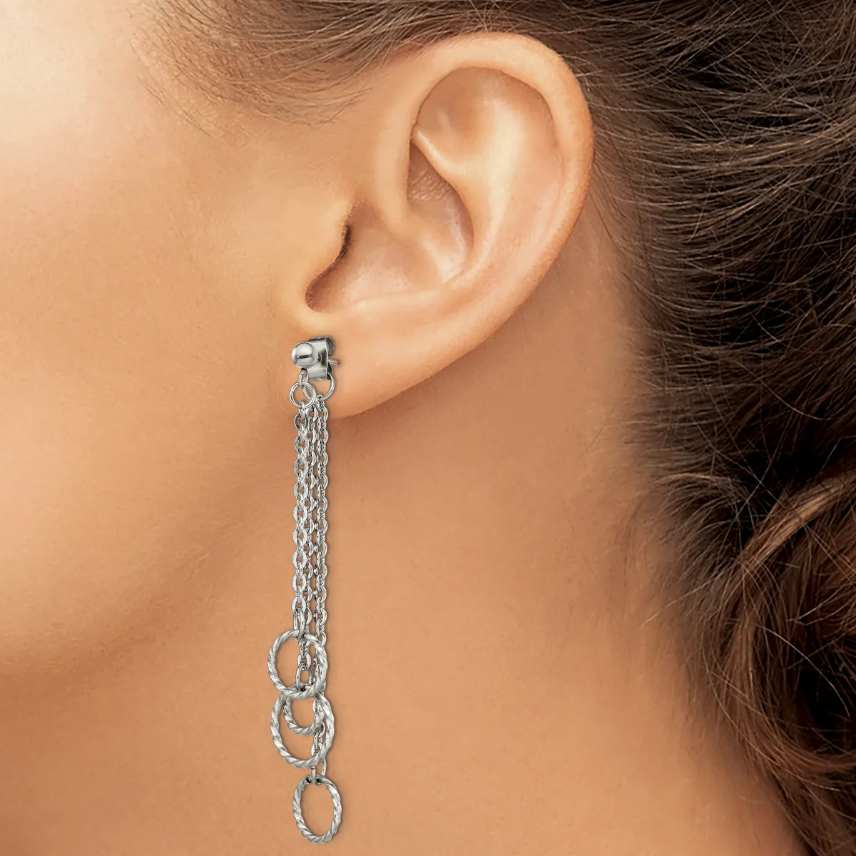A silver-toned chain dangle earring with textured oval links hangs from a stud post, worn on a person's ear.