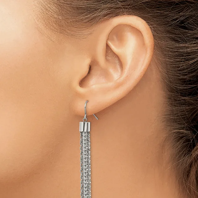 A long silver chain dangle earring with a textured cylindrical pendant hanging from a wire hook, shown worn on a person's ear.