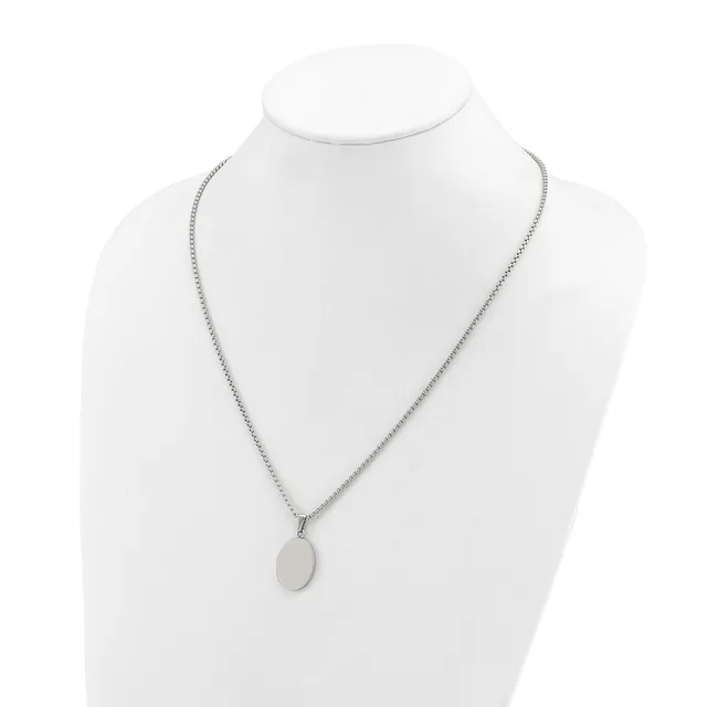 A silver-toned chain necklace with a small oval pendant displayed on a white mannequin bust.