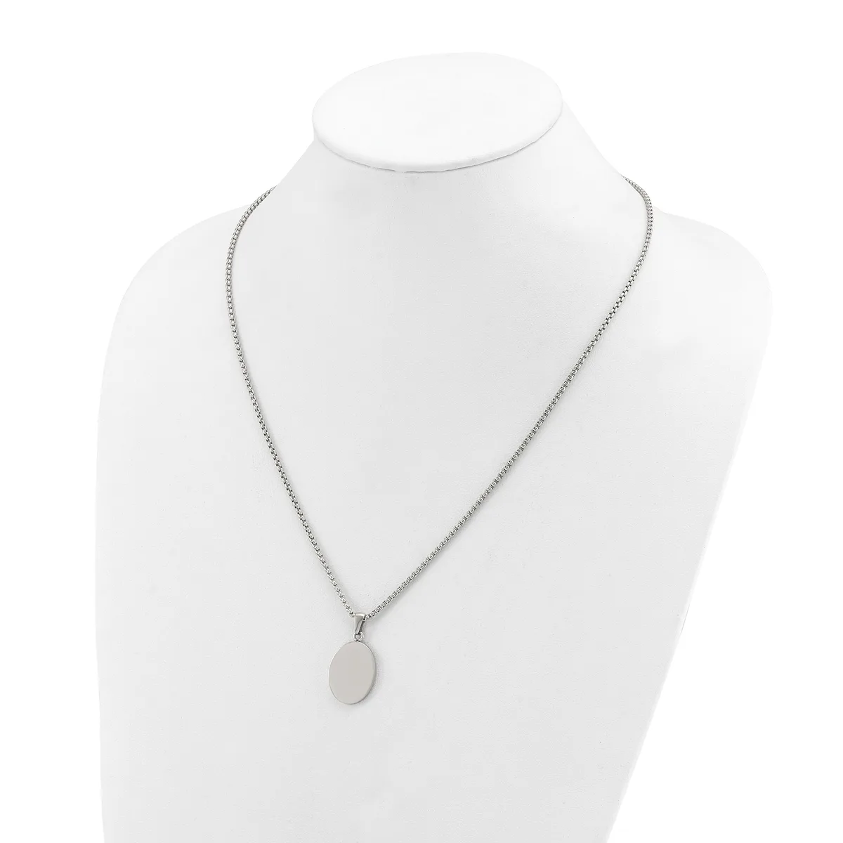 A silver-toned chain necklace with a small oval pendant displayed on a white mannequin bust.