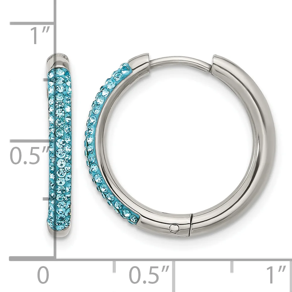 A pair of silver-tone hoop earrings with turquoise crystals embedded along the outer surface, shown with a measurement scale indicating approximately one inch in length.