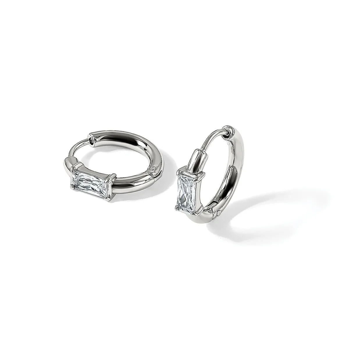 A pair of silver hoop earrings with rectangular baguette-cut crystals mounted on the front of each hoop, displayed against a white background.
