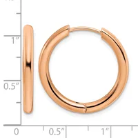 A pair of polished rose gold hoop earrings with a thick, rounded profile, shown next to a measurement scale indicating approximately one inch in diameter.