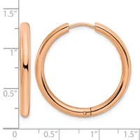 A pair of rose gold hoop earrings with a polished finish, shown next to a measurement scale indicating they are approximately one inch in diameter.