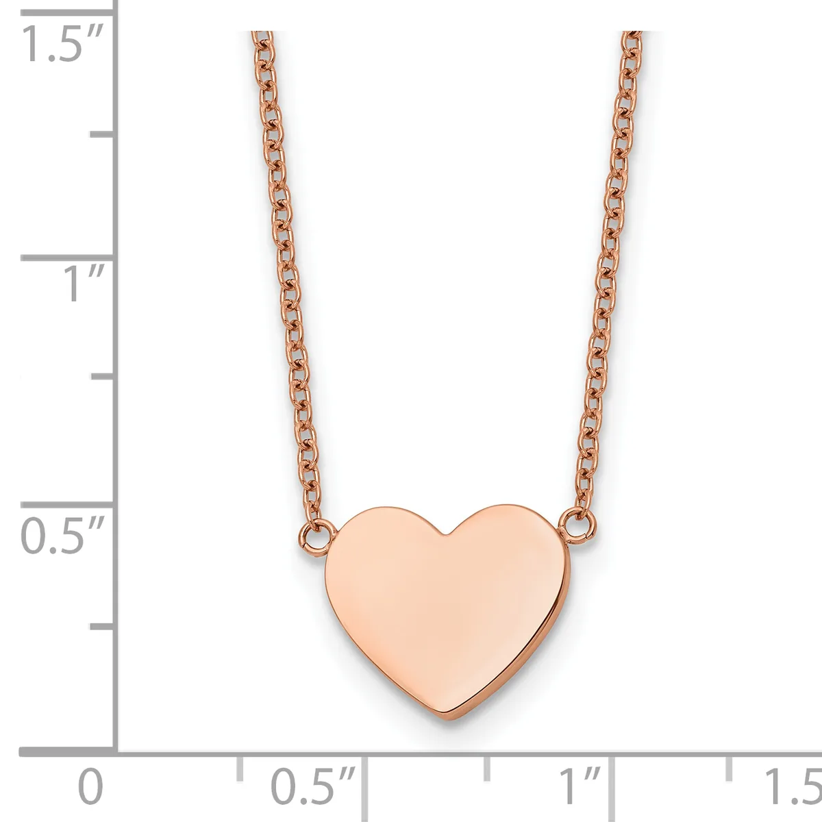 Rose gold heart pendant on a rose gold chain necklace, shown against a ruler measuring approximately 1.5 inches in length.