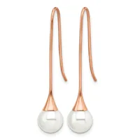 Pair of rose gold threader earrings with white pearl drops and long curved wires passing through the ear.