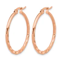 A pair of rose gold hoop earrings with a textured hammered finish and hinged clasp closures, displayed against a white background.