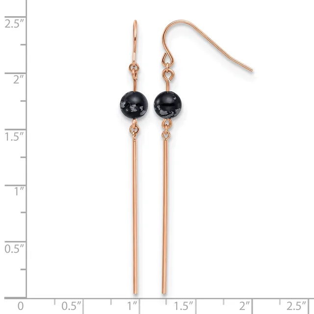 Pair of rose gold-toned earrings with black spherical stones suspended above long thin bars, shown on a measurement scale.