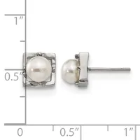A pair of silver stud earrings with square bezels containing white pearls, shown next to a ruler indicating approximately half-inch dimensions.