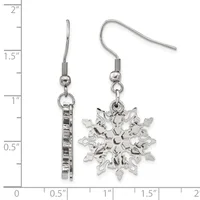 A pair of silver-tone snowflake charm earrings with matching ear wires, displayed on a measurement scale showing approximately one inch in length.
