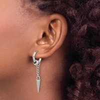 A person wearing a silver hoop earring with a dangling spike pendant in their pierced earlobe.
