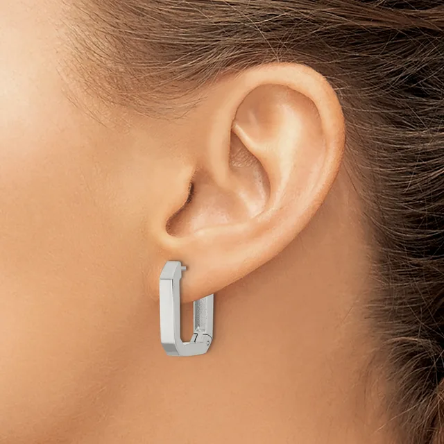 A woman wearing small rectangular polished silver hoop earrings, shown in profile from the side of her head and neck.