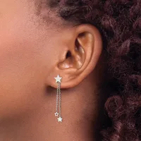A person wearing a silver star-shaped earring with a chain and dangling star pendant visible on their earlobe.