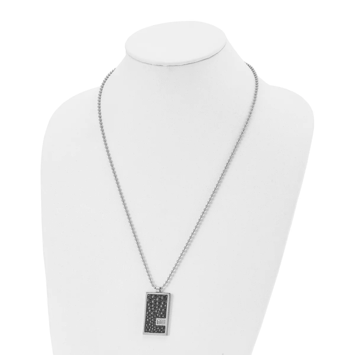 Silver-toned rectangular pendant necklace with textured surface displayed on a white bust form.