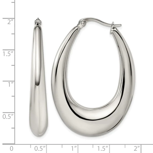 A pair of polished silver-toned oval hoop earrings displayed next to a ruler showing they measure approximately two inches in length.