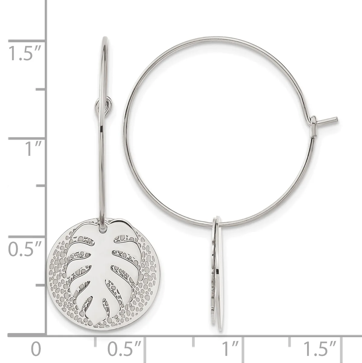 Silver hoop earrings with a circular leaf-motif charm pendant hanging from one ear wire, shown against a measurement scale.