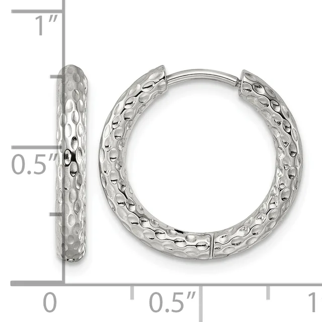 A pair of silver hoop earrings with a textured hammered surface, shown front and side view against a measurement scale indicating approximately one inch in height.
