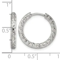 A pair of silver hoop earrings with a textured hammered surface, shown front and side view against a measurement scale indicating approximately one inch in height.