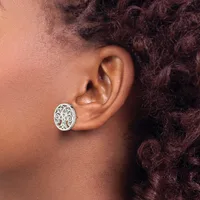 A person wearing a silver filigree oval stud earring with intricate openwork design on their earlobe.