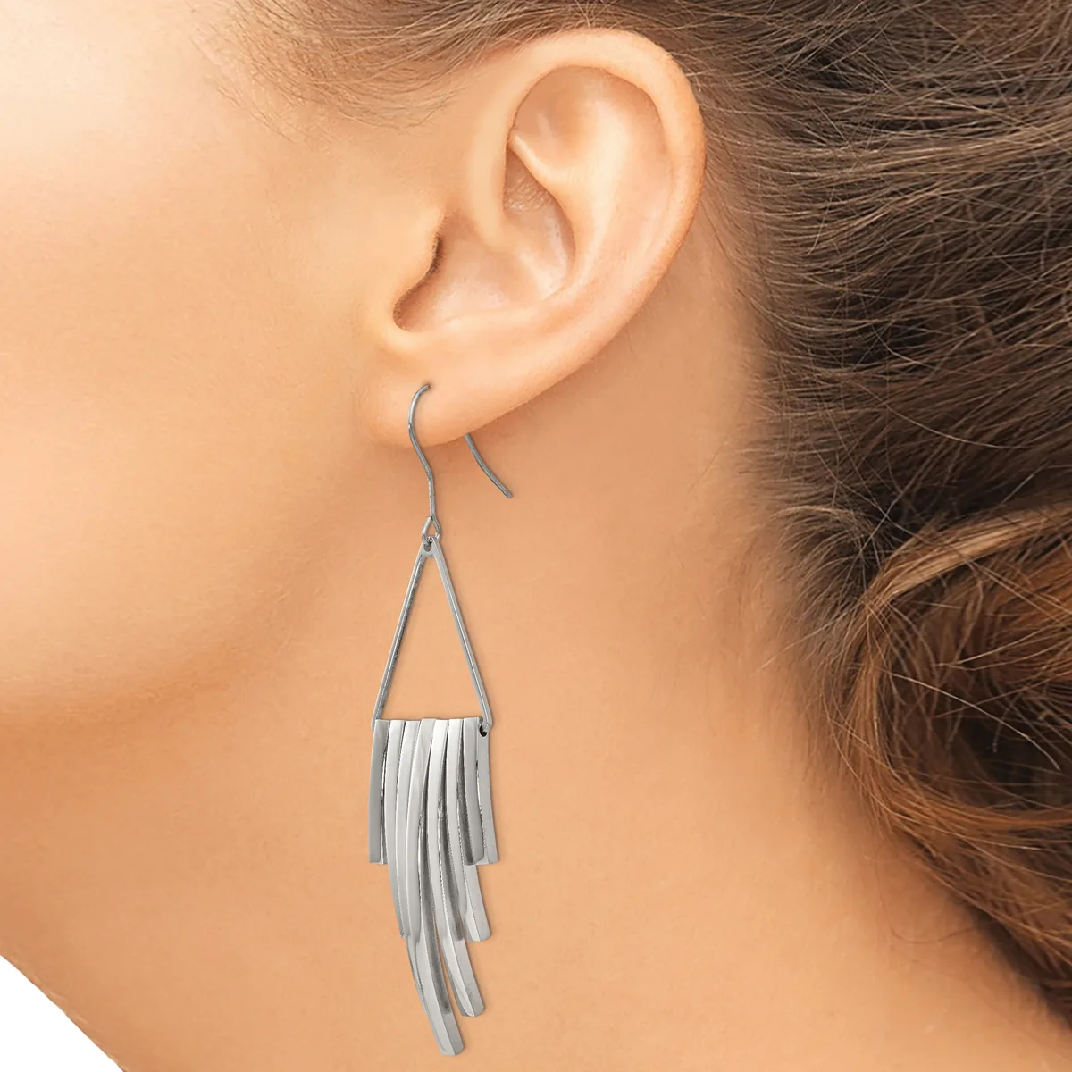 Silver-toned tassel earrings with triangular tops and long fringe strands hanging from a woman's ears.