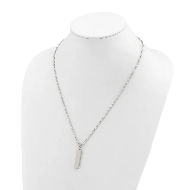 A silver-toned chain necklace with a small rectangular pendant displayed on a white mannequin bust.