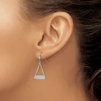 A woman wearing a triangular diamond dangle earring with a curved bail, shown from the side view of her ear and neck.