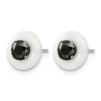 A pair of round white ceramic stud earrings with faceted black gemstones set in the center, displayed against a white background.