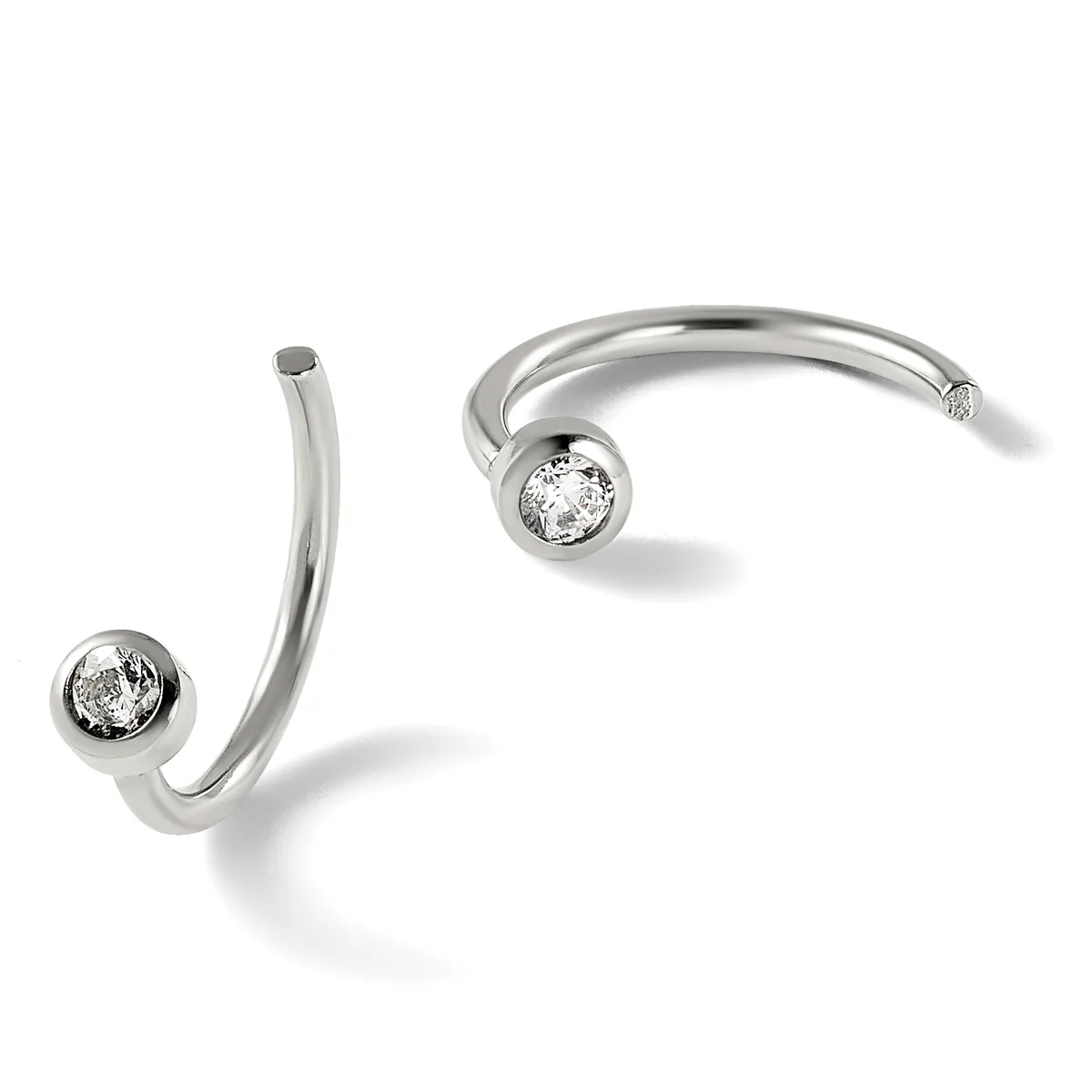 Two silver curved cuff bracelets with round diamond settings at the ends, displayed against a white background.