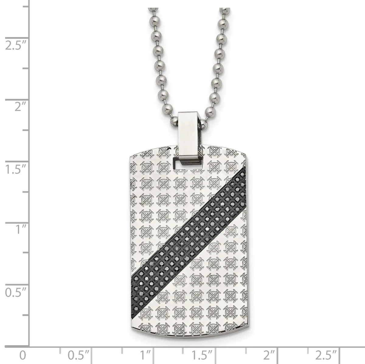 Stainless steel dog tag pendant with repeating skull pattern and black diagonal stripe, suspended from a ball chain, displayed against a measurement ruler.