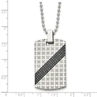 Stainless steel dog tag pendant with repeating skull pattern and black diagonal stripe, suspended from a ball chain, displayed against a measurement ruler.