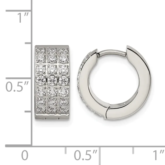 A pair of silver huggie hoop earrings with pave-set cubic zirconia stones, shown next to a ruler indicating their dimensions of approximately one inch tall and half inch wide.