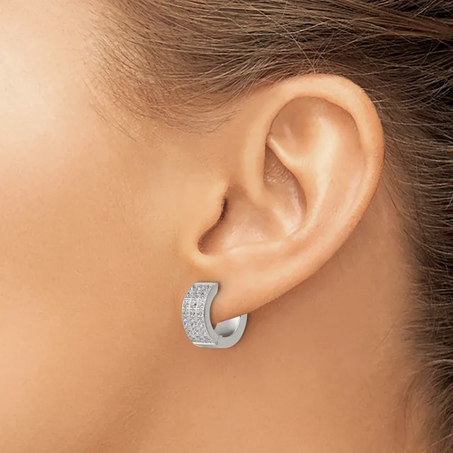 A silver chunky hoop earring with a textured surface set with small cubic zirconia stones, worn on a person's ear.