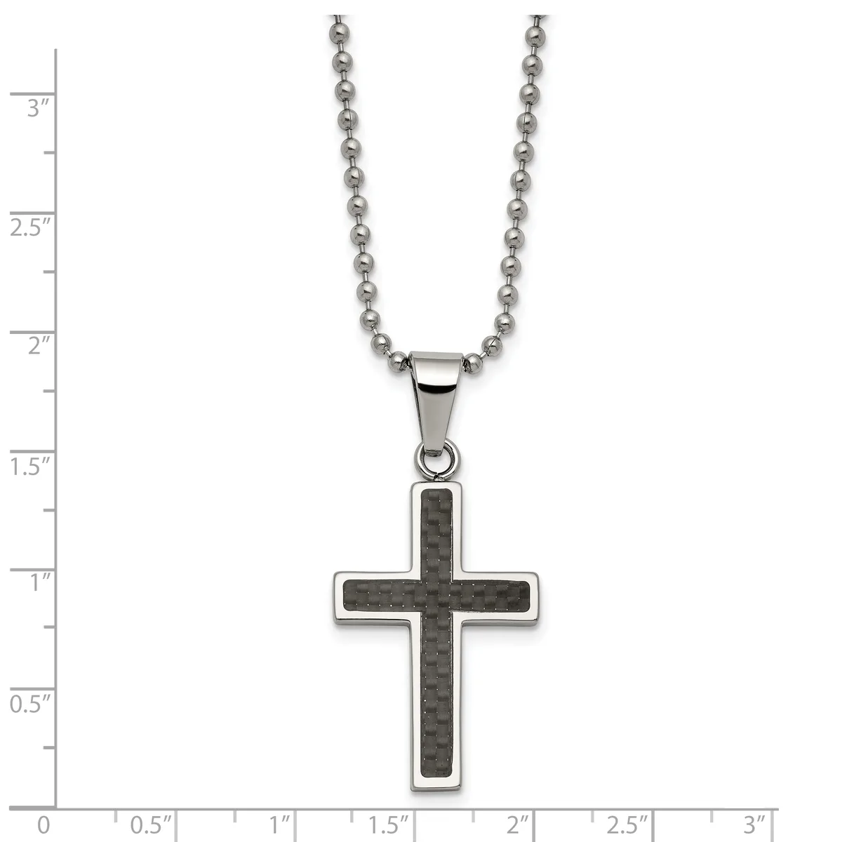 A stainless steel ball chain necklace with a cross pendant featuring a dark carbon fiber inlay, displayed on a measurement scale.