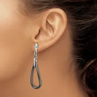 A woman wearing a silver teardrop-shaped dangle earring with a chain attachment, shown from the side view of her ear and neck.