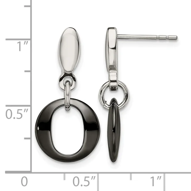 A pair of two-tone drop earrings with polished silver oval tops and black circular rings hanging below, displayed against a measurement scale.