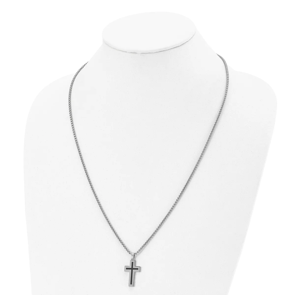 A silver-toned chain necklace with a small cross pendant displayed on a white mannequin bust.
