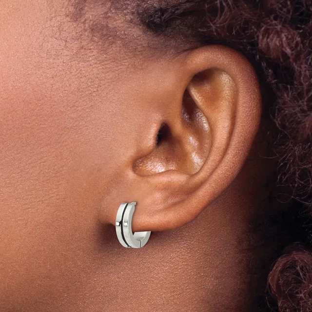 Close-up side view of a person's ear wearing a polished silver hoop earring with a small rectangular accent detail.