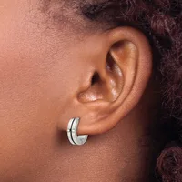 Close-up side view of a person's ear wearing a polished silver hoop earring with a small rectangular accent detail.