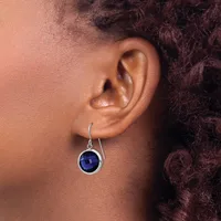 A person wearing a silver hook earring with a round deep blue stone set in a circular bezel, shown from the side view of their ear and neck.