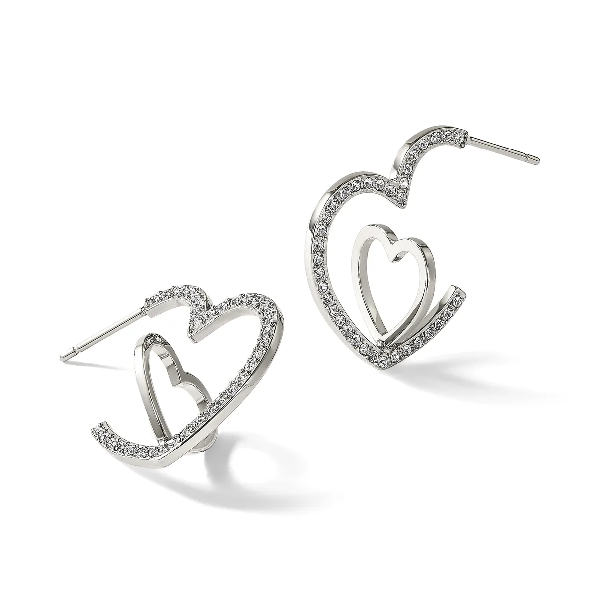 A pair of silver-toned heart-shaped hoop earrings with crystal embellishments along the outer edges, shown from front and side angles.