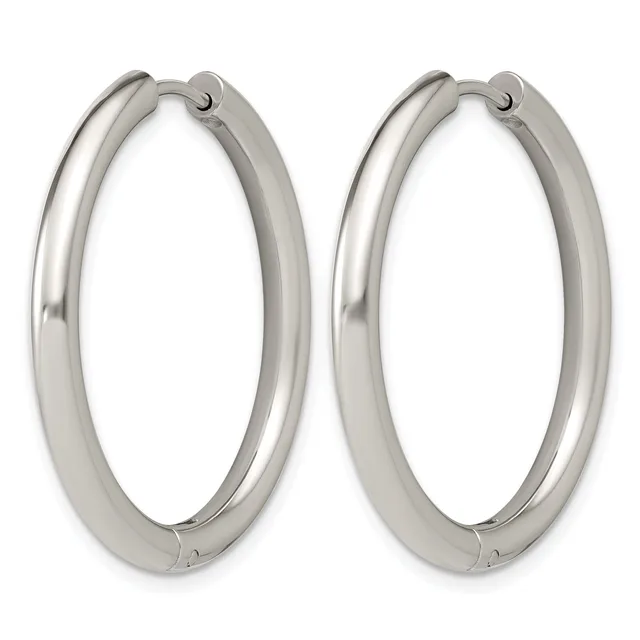 A pair of polished silver-toned hoop earrings with a thick tubular design and hinged closures, shown against a white background.