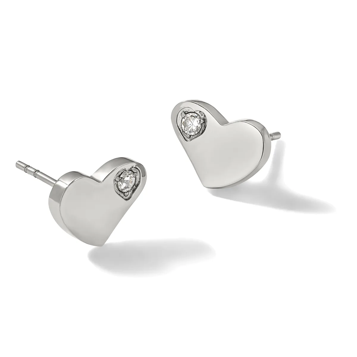 A pair of silver heart-shaped stud earrings, each featuring a small round diamond set at the top, displayed at angles against a white background.