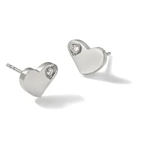 A pair of silver heart-shaped stud earrings, each featuring a small round diamond set at the top, displayed at angles against a white background.