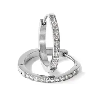 Three silver hoop earrings arranged in a display, two with pavé-set diamonds and one with a brushed finish.