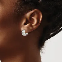 A person wearing a small silver hoop earring with a textured finish, shown in profile against a neutral background.