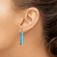 A person wearing a long rectangular turquoise pendant earring with dark veining, hanging from a small silver post stud.