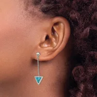 A person wearing a long dangling earring with a turquoise triangular stone suspended from a delicate chain attached to a stud post.