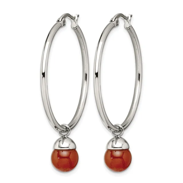 Pair of silver-toned hoop earrings with polished oval loops and red spherical stone drops suspended from small caps.