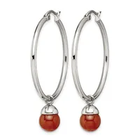 Pair of silver-toned hoop earrings with polished oval loops and red spherical stone drops suspended from small caps.