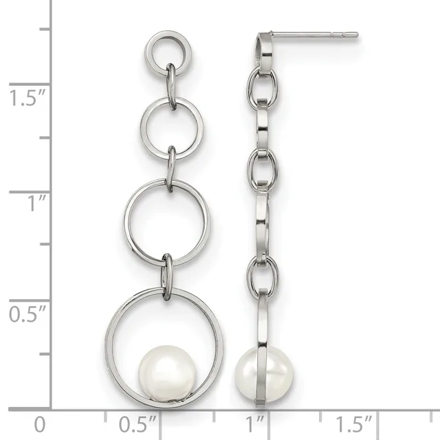 A pair of silver-toned dangle earrings with progressively larger rings linked together, each suspending a white pearl at the bottom, shown against a measurement scale.